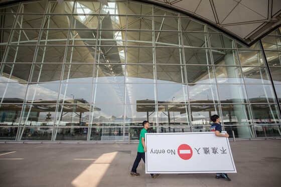 China Likens Protesters to ‘Terrorists’ as Airport Curbs Access