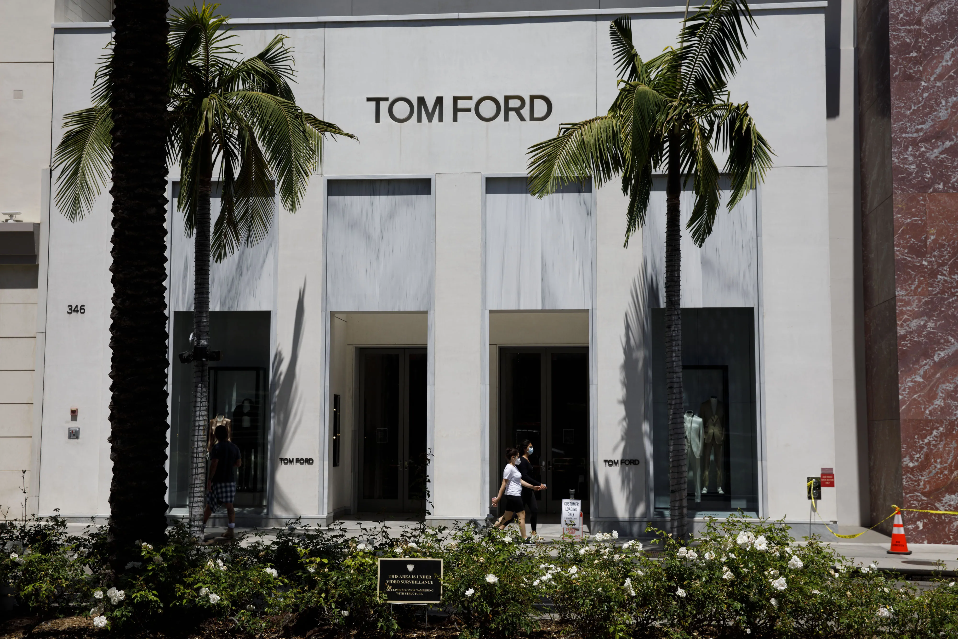 Pedestrians wearing masks walk past a Tom Ford retail store on Rodeo Drive in Beverly Hills, California, U.S., on Tuesday, May 19, 2020. T