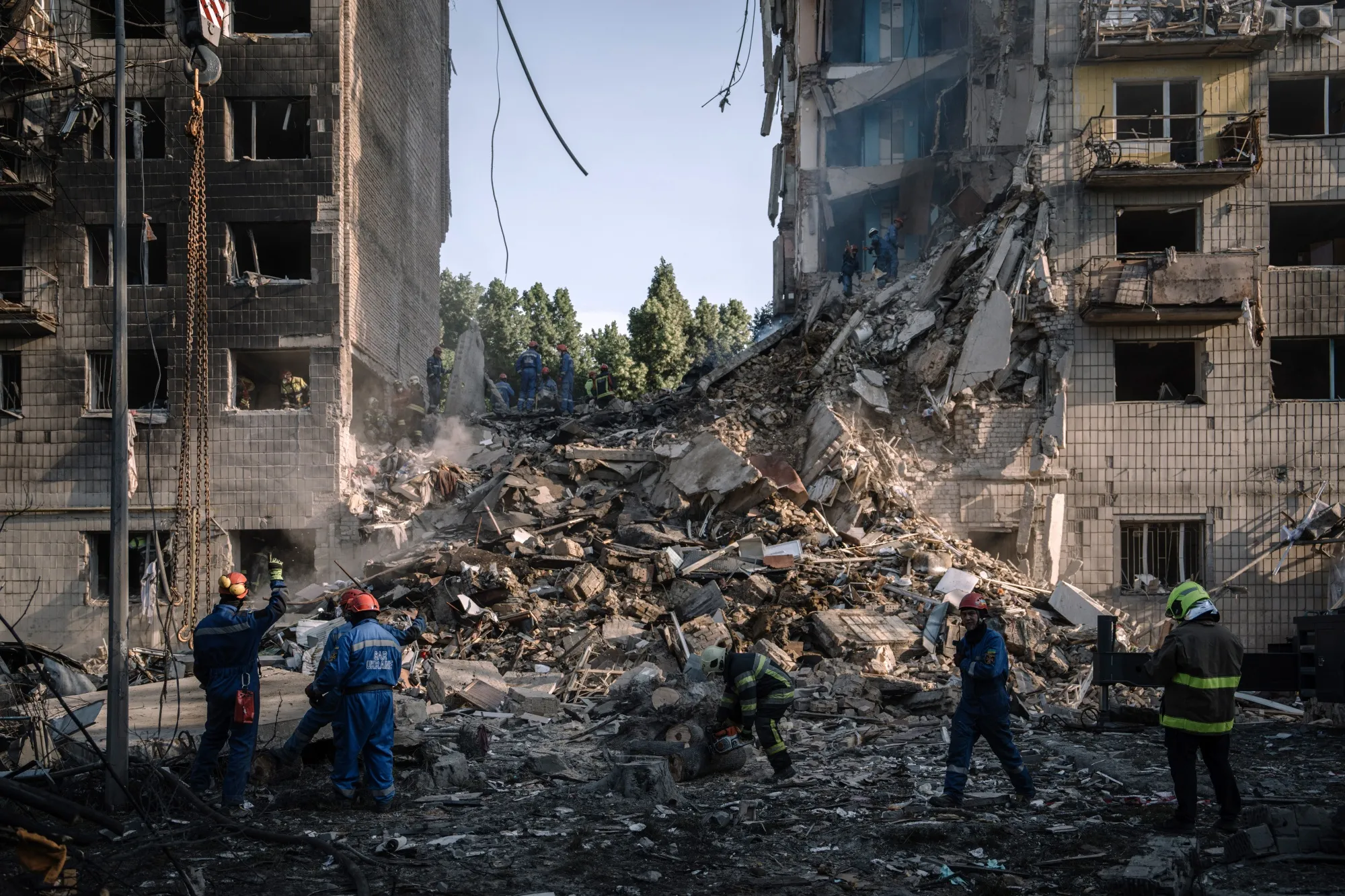 Rescue services search for victims under wreckage after an air strike on a residential building in Kyiv.