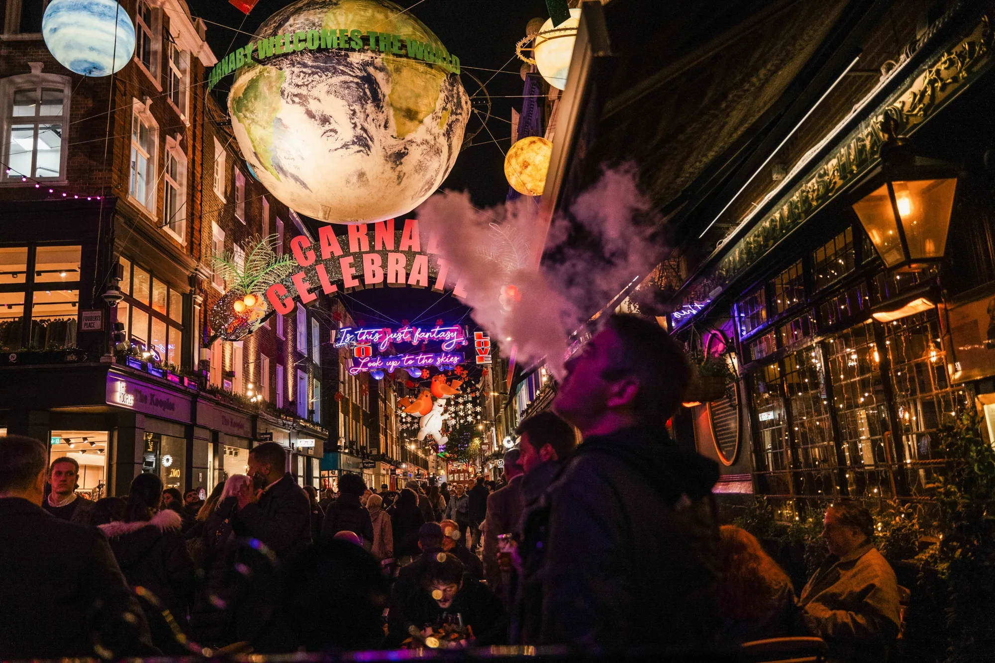 A customer smokes an electronic cigarette outside a pub in the Soho district of London.
