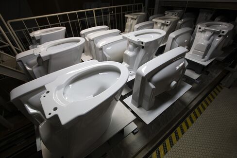 Toilets and wash basins exit a kiln at a Lixil Group plant.