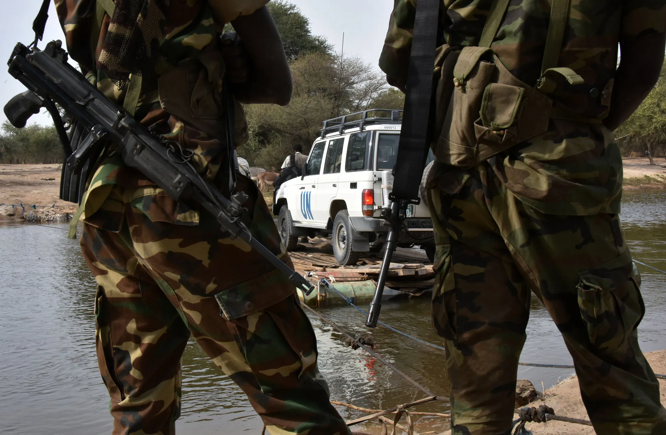 Chadian soldiers watching as a UN vehicle from a United Nations' refugee agency (UNHCR) convoy heads towards the UNHCR camp in N'Gouboua.
