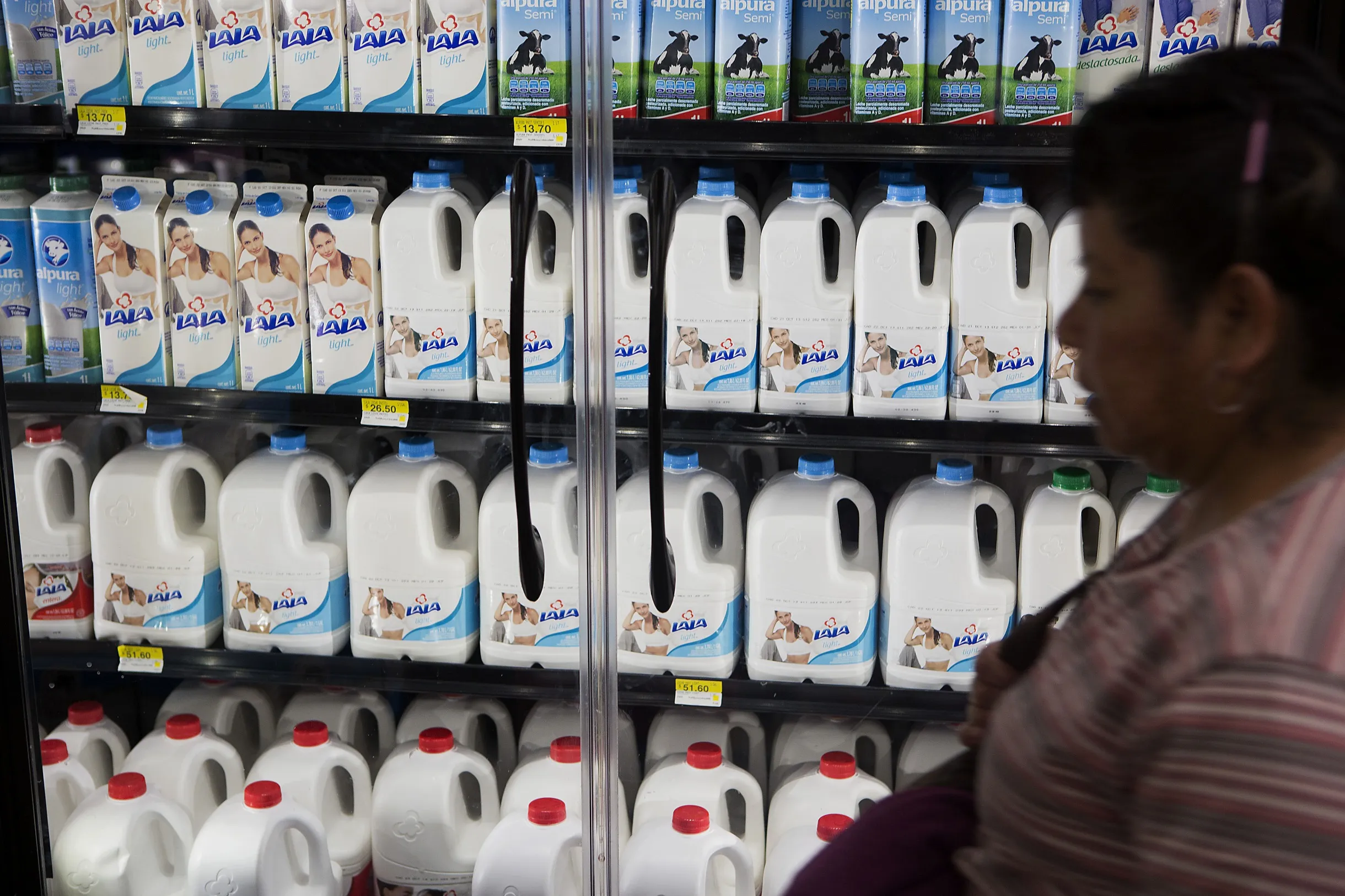 A customer looks at milk at a supermarket in Mexico City.