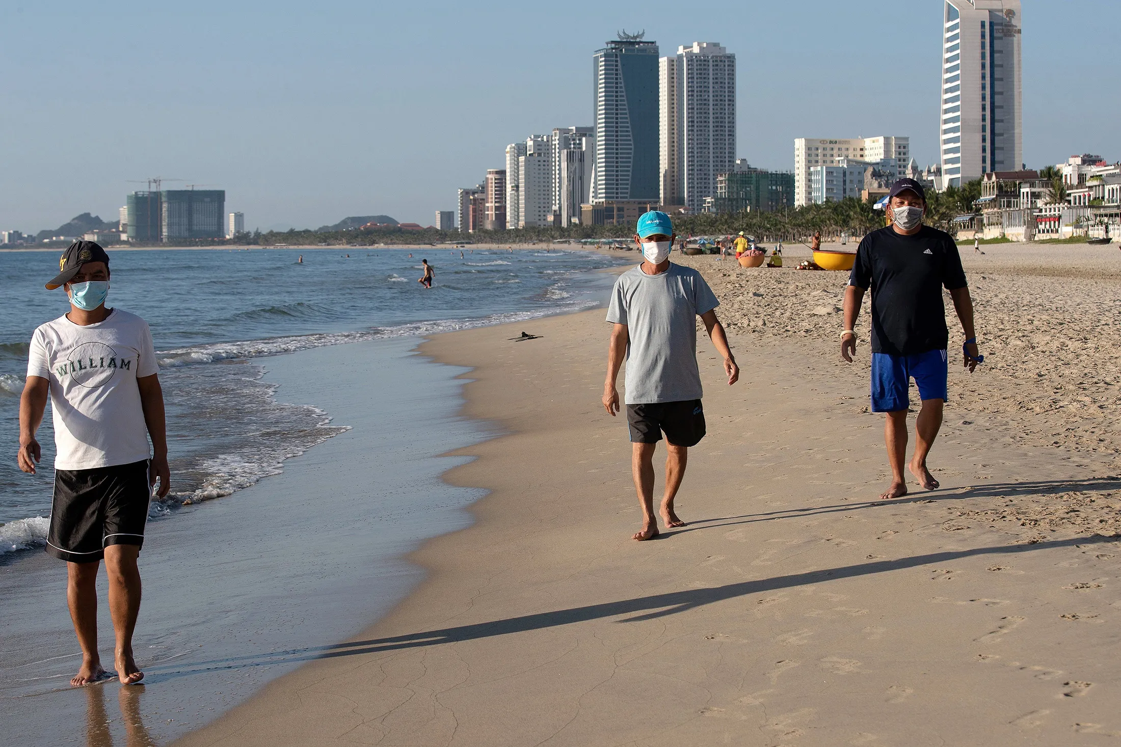 People walking along the beach&nbsp;in Danang in July.