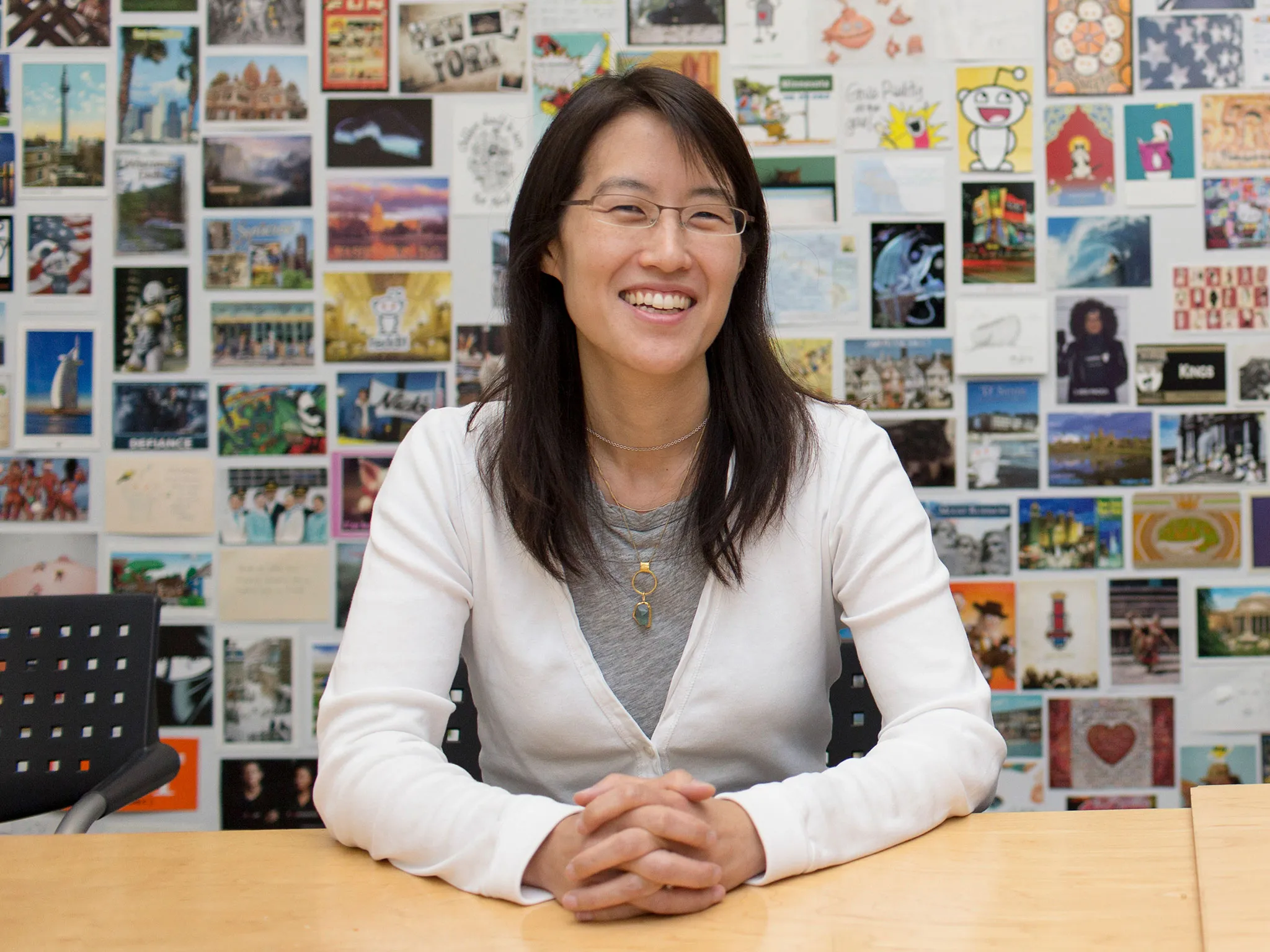 Ellen Pao, head of business strategy for the web-based community message board Reddit, in front of a wall of postcards sent in by users at the company's offices in San Francisco, on July 16, 2014.
