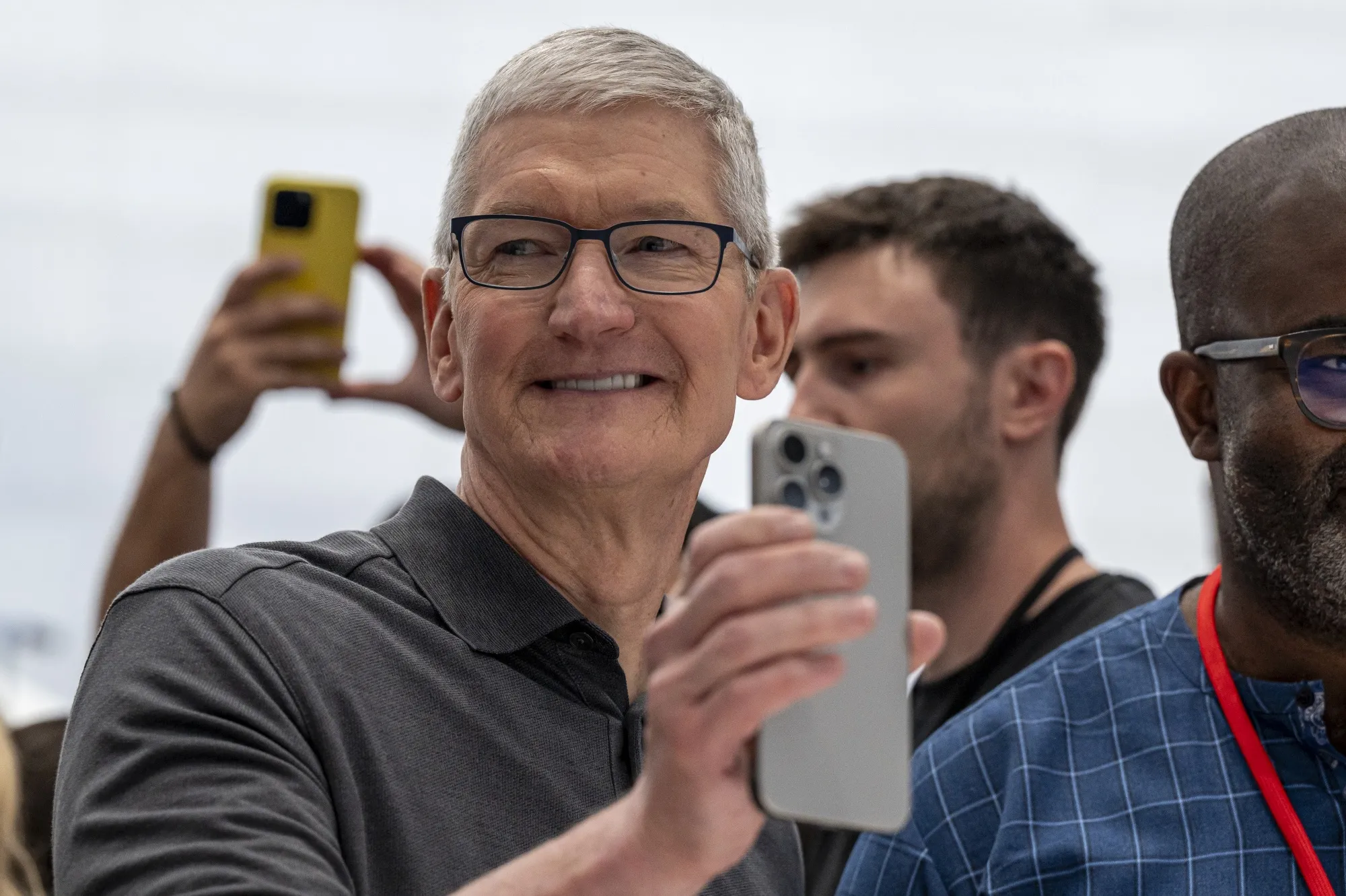 Apple Chief Executive Officer Tim Cook holding up the iPhone 15 Pro Max.