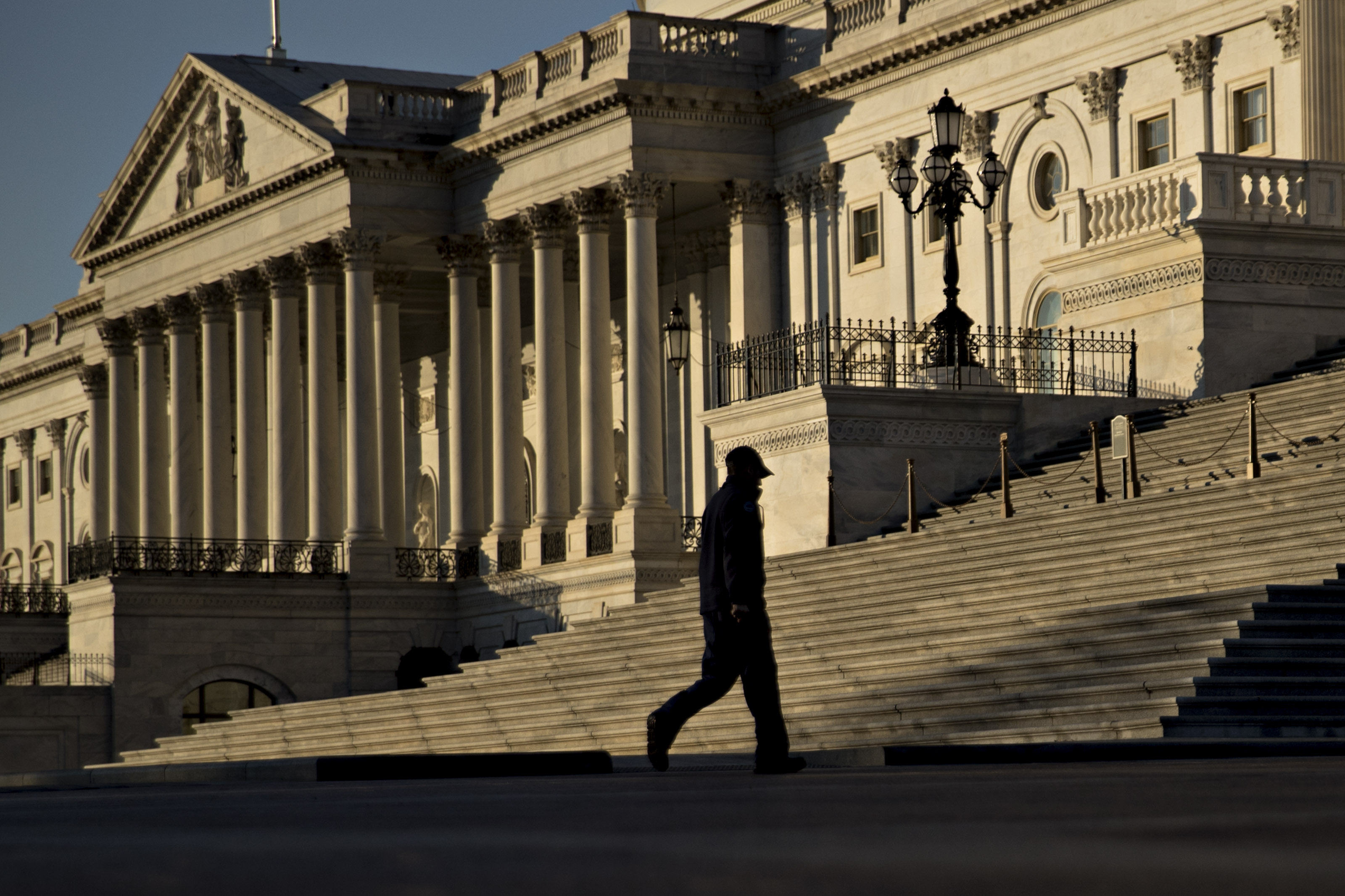 A man walks near the U.S. Capitol in Washington, D.C., U.S., on Tuesday, Dec. 19, 2017. Congressional Republicans kicked off the final leg of their six-week legislative sprint to overhaul the U.S. tax code and deliver a major policy victory for President Donald Trump before years end. The House is scheduled to vote Tuesday on the tax bill and Senate leaders intend to bring the measure up as soon as they get it.