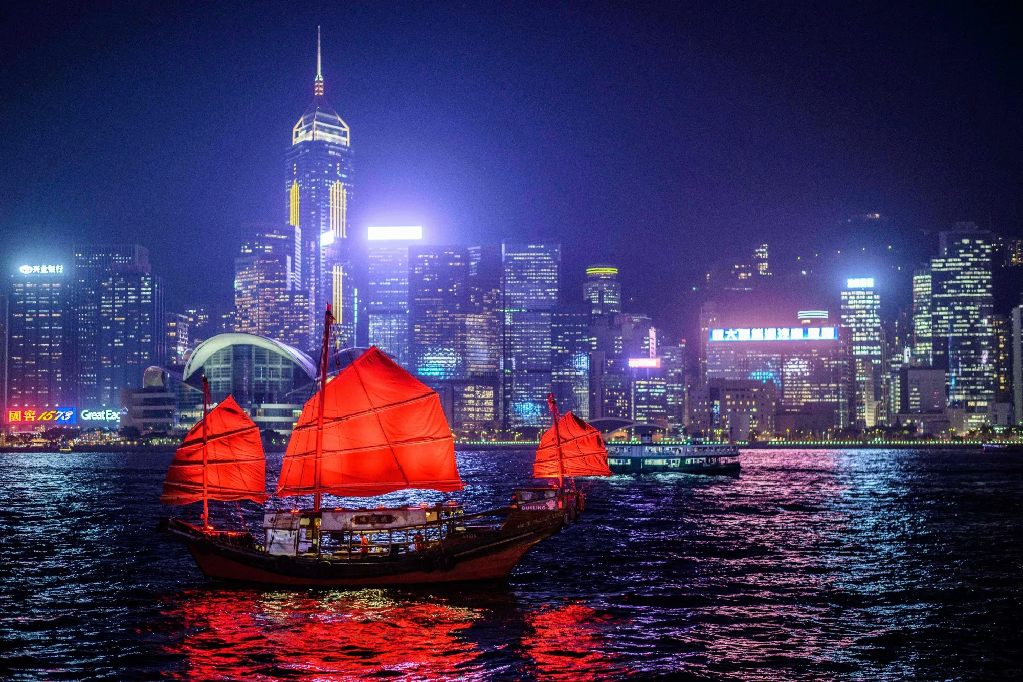 A traditional wooden boat sails in Victoria Harbor in Hong Kong.