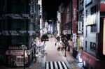 Pedestrians walk along a near-empty street in Shinjuku district in Tokyo on April 10.