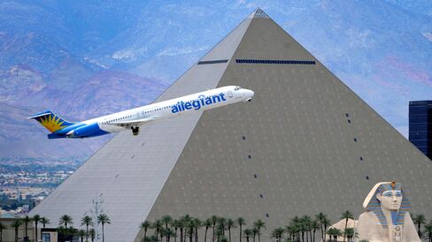 An Allegiant Air jetliner flies by the Luxor Resort and Casino after taking off from McCarran International Airport in Las Vegas on May 9, 2013.
