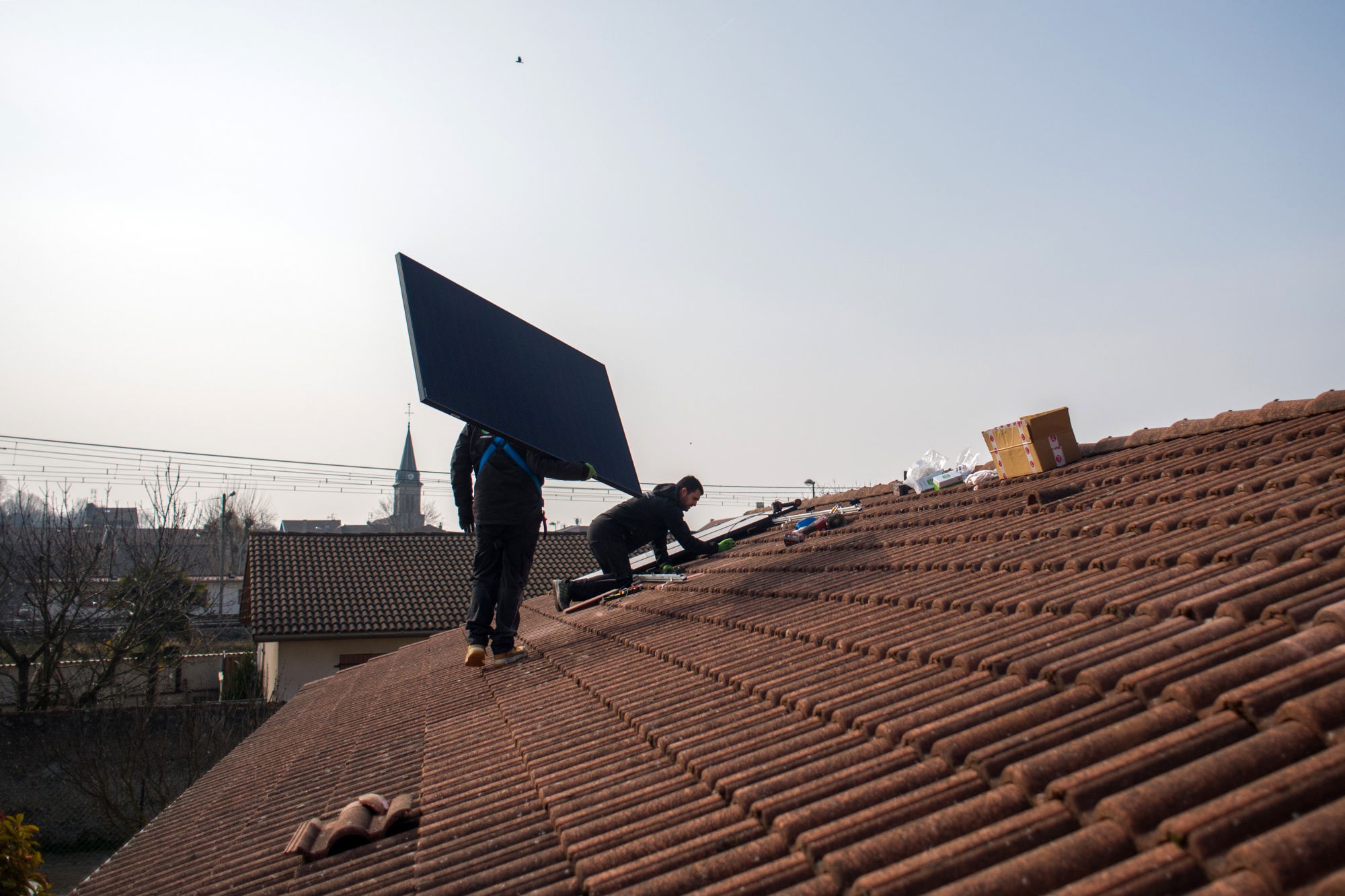 Engineers fix solar panels onto a roof in Saint Denis en Bugey, France.