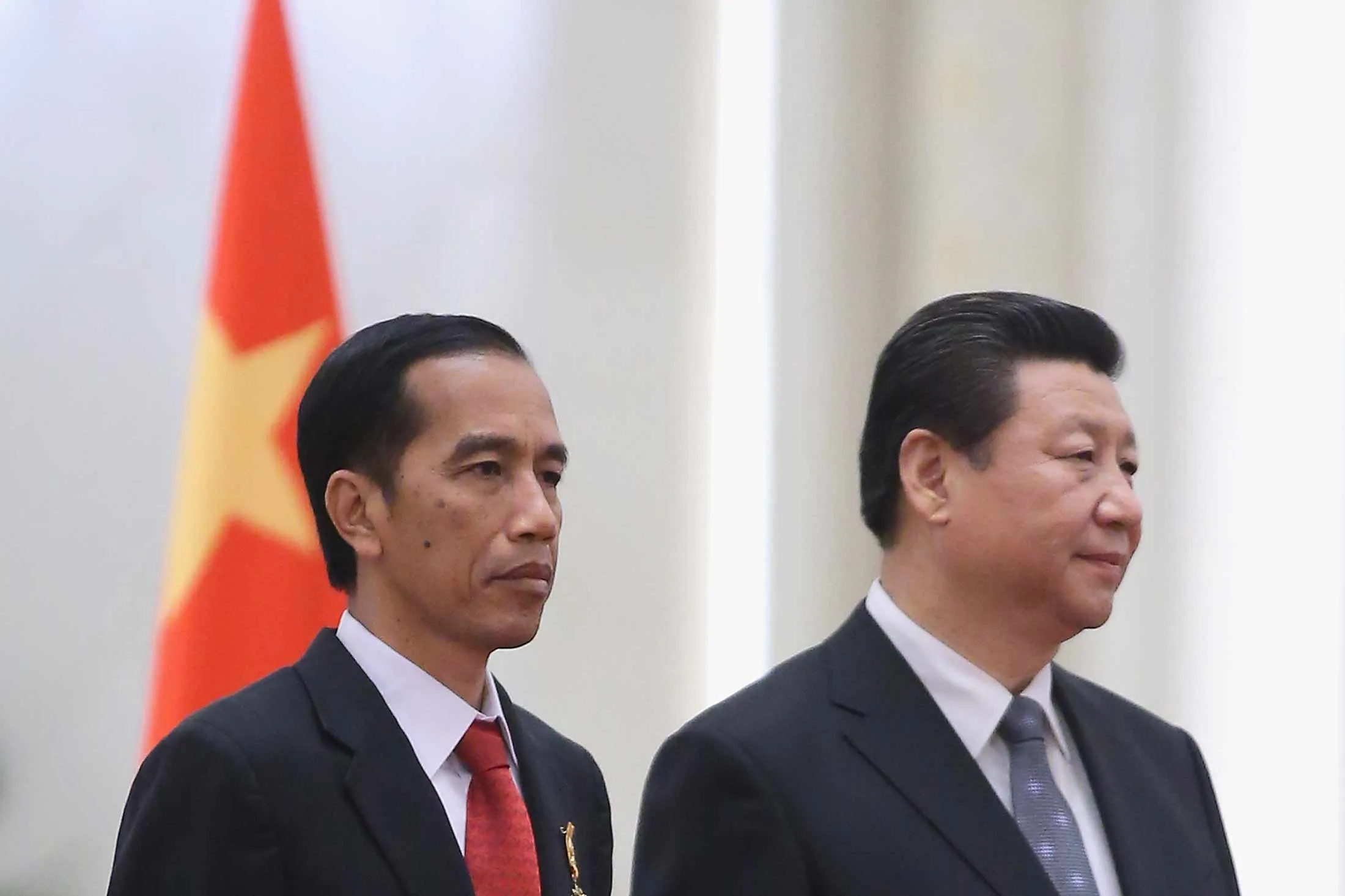 Chinese President Xi Jinping, right, accompanies Indonesia's President Joko Widodo to view an honor guard during a welcoming ceremony inside the Great Hall of the People on March 26, 2015 in Beijing, China.
