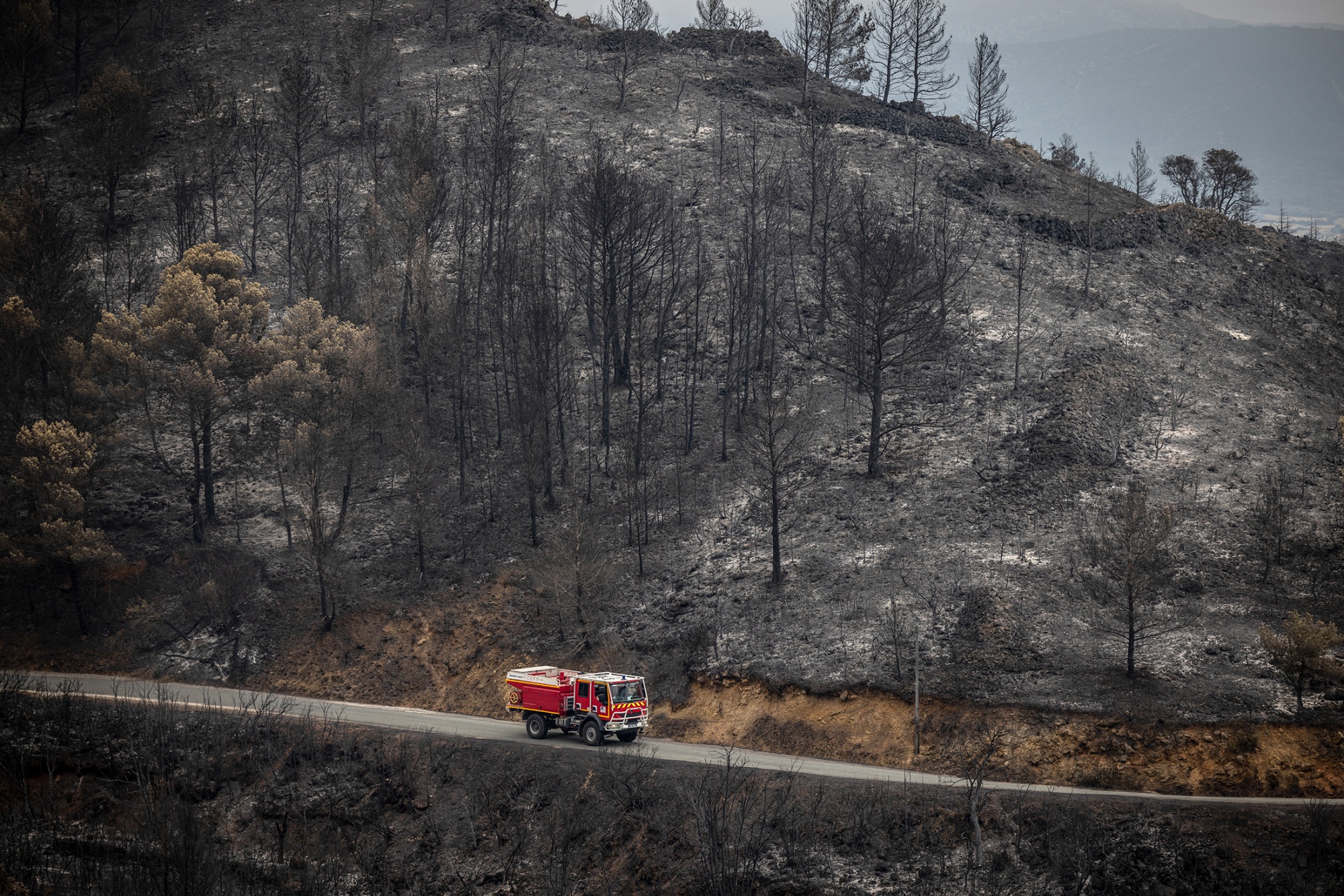 A firefighter truck on burnt woodland following a wildfire in Fontjoncouse, Aude, France, on Friday, Aug. 8, 2025. Firefighters say they’ve made progress containing France’s worst wildfires in more than seven decades, with light rain providing a chance to contain the blazes before temperatures rise again in the coming days. Photographer: Angel Garcia/Bloomberg