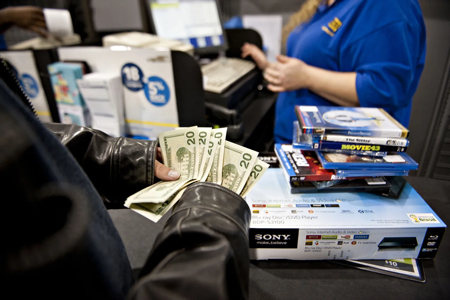 A customer counts his money as he prepares to pay for merchandise at a Best Buy Co. store in Peoria, Illinois.
