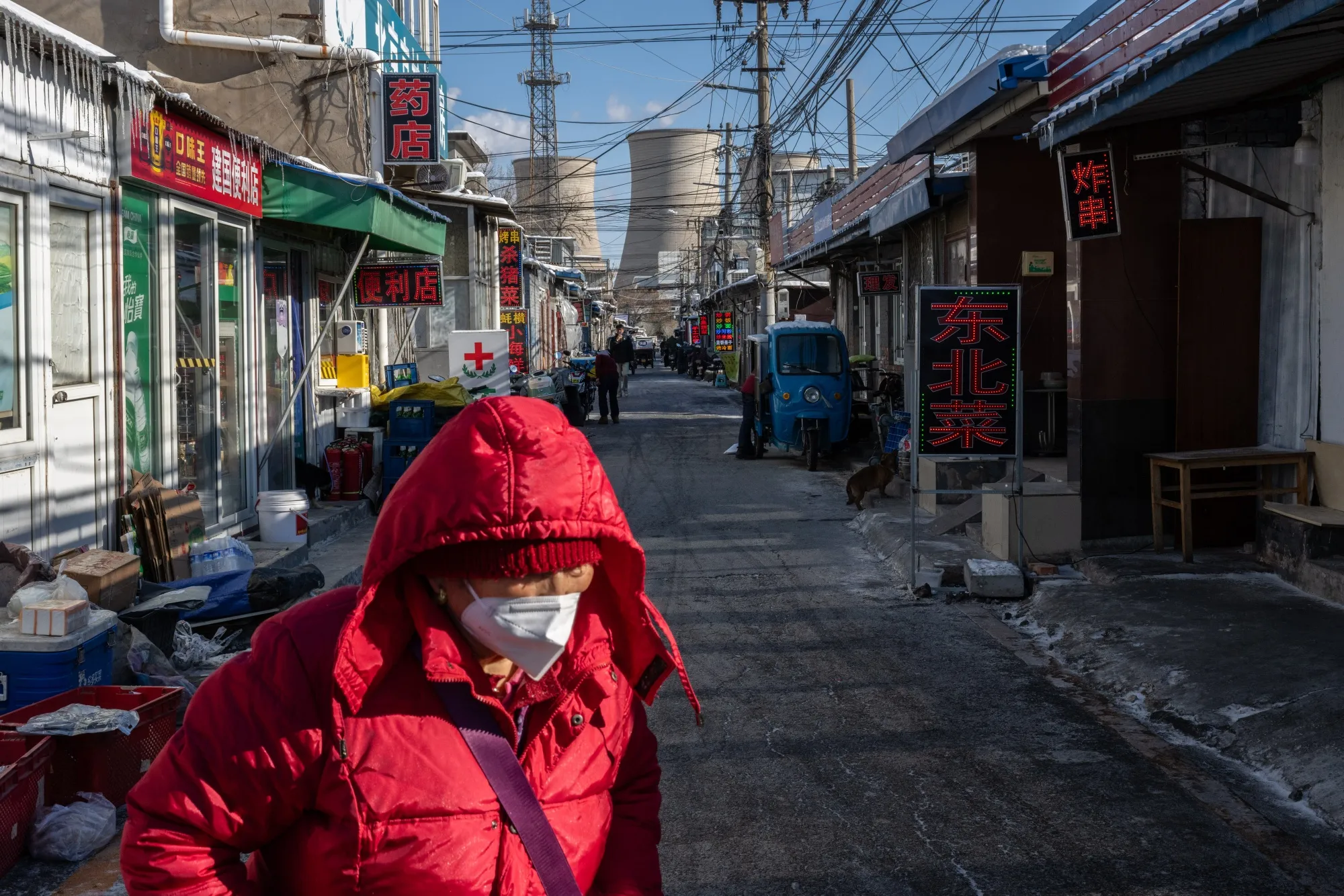 Pedestrians in front of a mixed gas-coal power plant in Beijing.