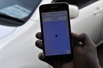 A driver holds a phone displaying the Uber mobile application in Nairobi.