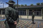 Anti-narcotics police officers stand guard over packages of cocaine, seized in Buenaventura, Colombia.