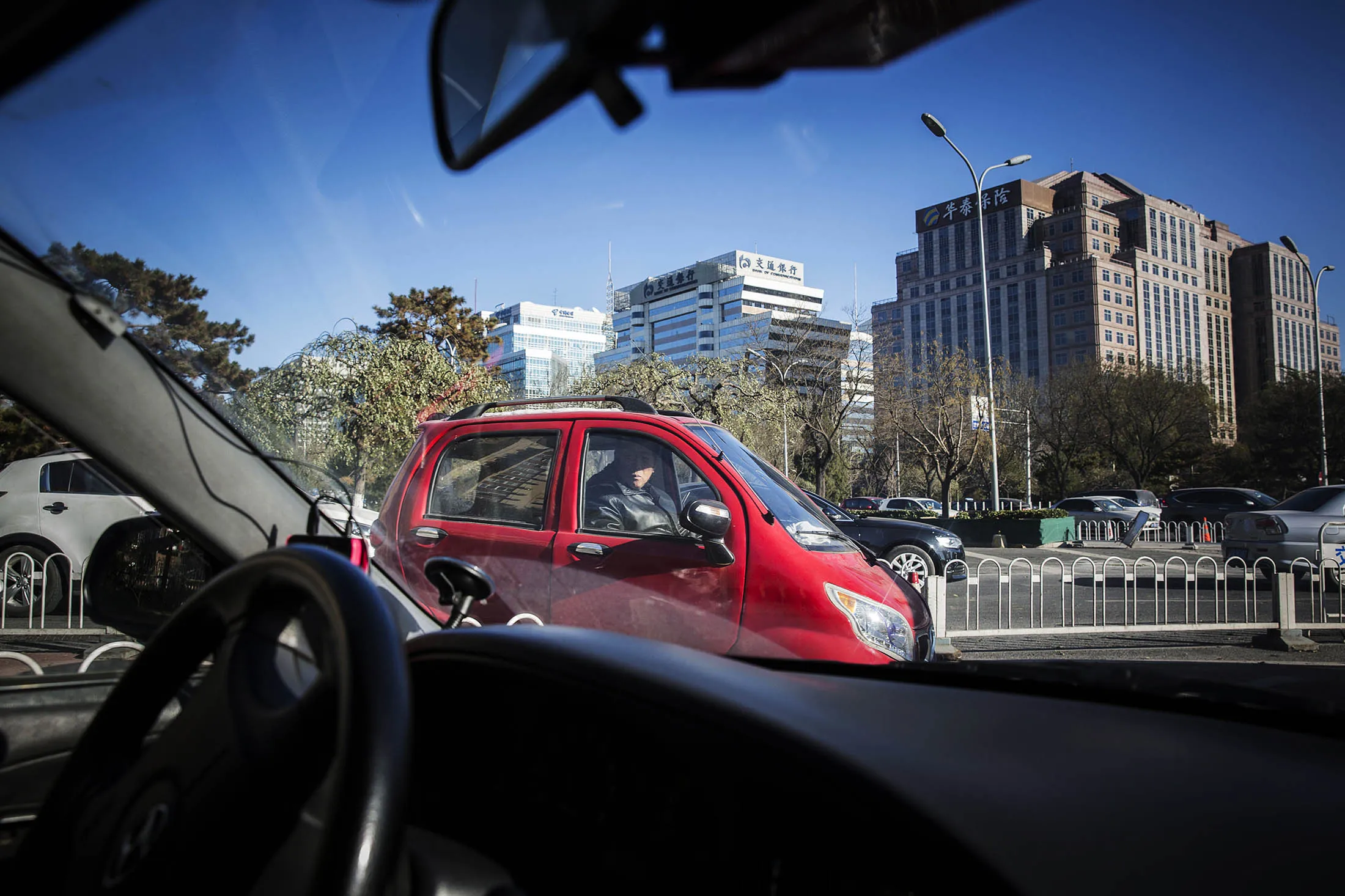 A man drives through an intersection in Beijing.
