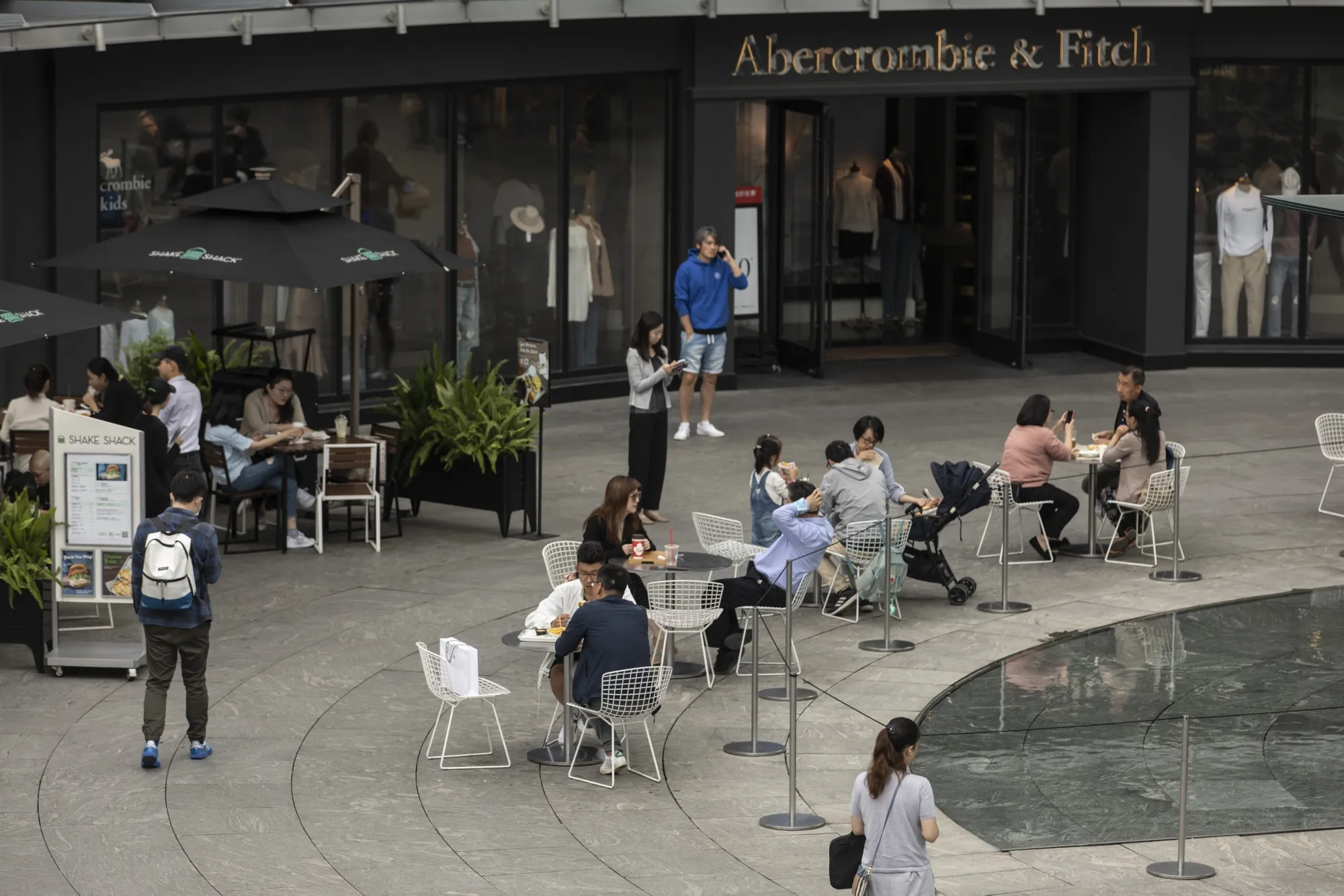 People sit outside a&nbsp;restaurant during lunch hour in the Lujiazui Financial District in Shanghai on Oct. 10.