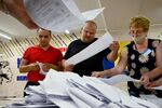 Members of a local electoral commission count ballots at a polling station&nbsp;in Chisinau on July 11.
