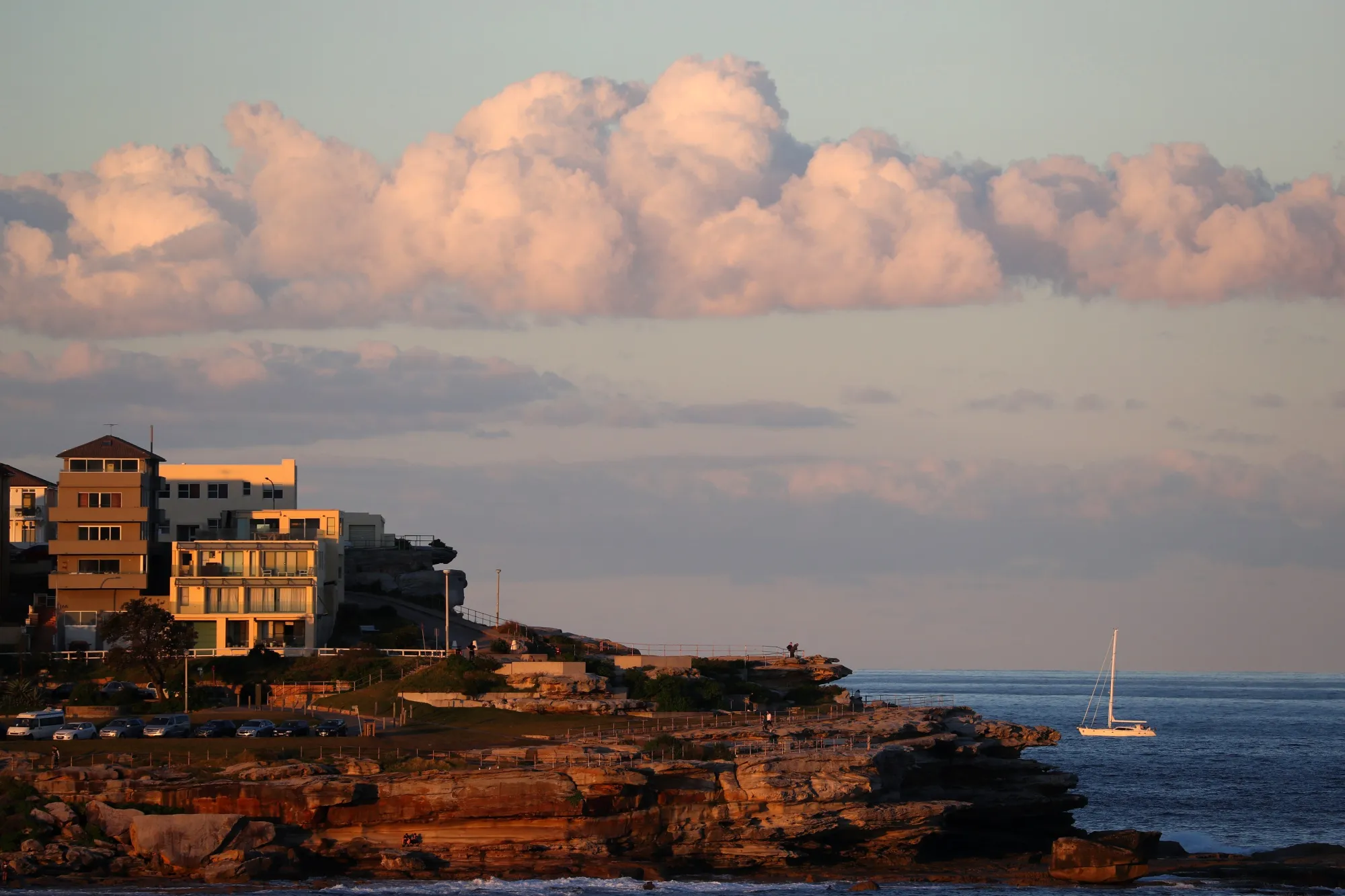 A yacht sails past residential buildings near Bondi Beach in Sydney, Australia.