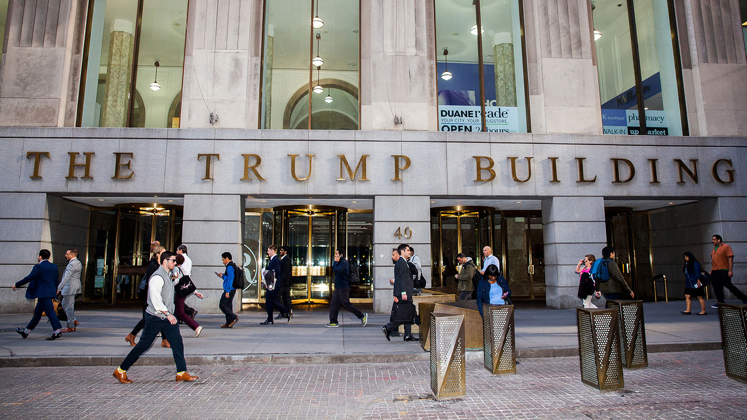 Pedestrians walk past the Trump Building on Wall Street in New York on April 18, 2016.
