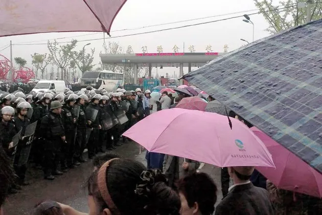 Chinese police with shields during a protest against the construction of a waste incinerator in Yuhang district, Hangzhou in China's Zhejiang province on May 11