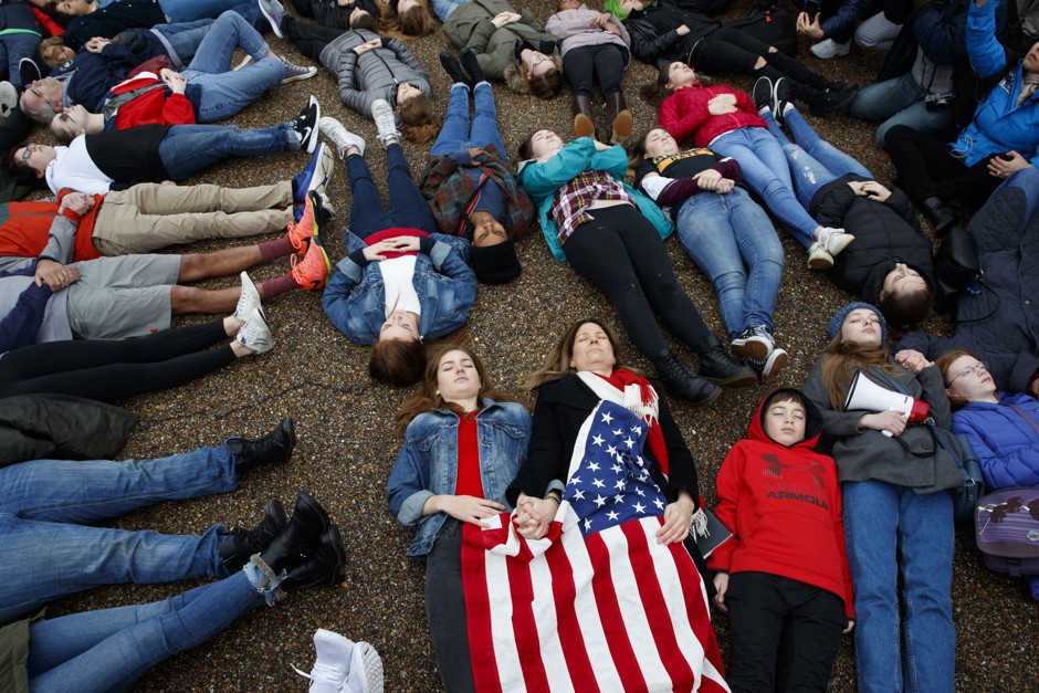 Eleanor Nuechterlein, 16, hold hands with her mother as they participate in a &quot;die-in&quot; during a protest in favor of gun control reform in front of the White House, Monday, Feb. 19, 2018.