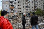 People stand in the middle of rubble&nbsp;after a rocket attack in Mykolaiv on Oct.&nbsp;23.
