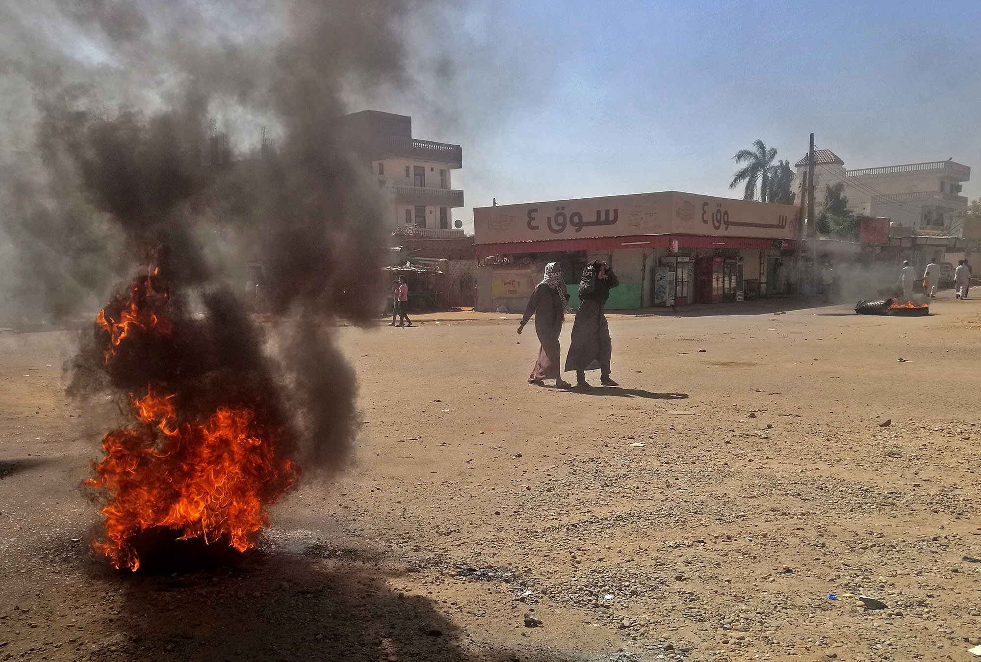 People walk past burning&nbsp;tires in Khartoum&nbsp;on Jan.&nbsp;18, 2019.&nbsp;