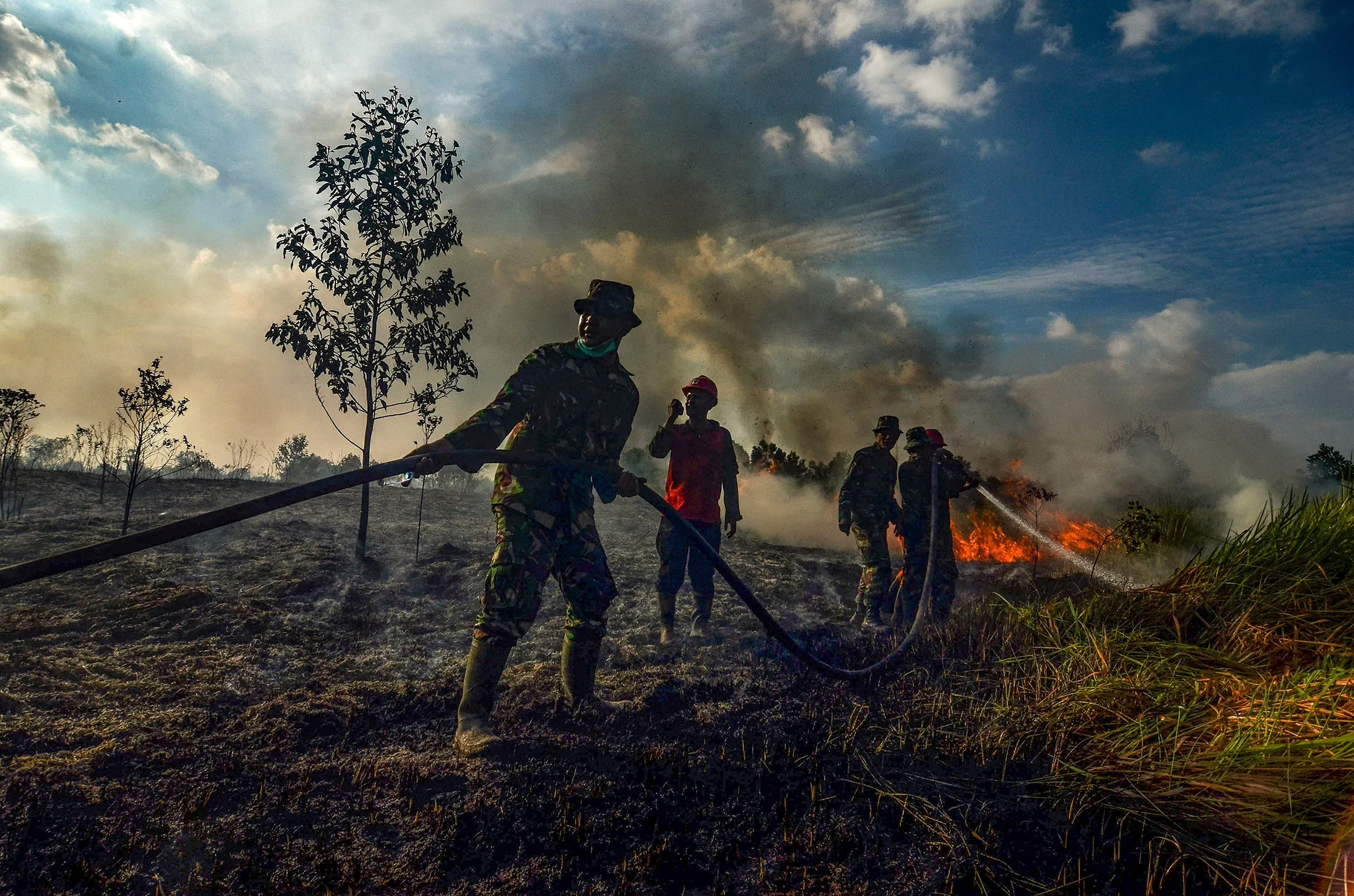 Forest and land fire task force officers douse a fire at a palm oil plantation in Riau province.