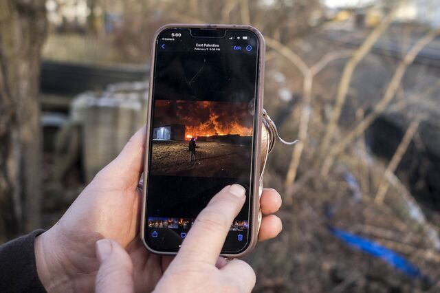 Brendan Foster shows her cellphone with a photo showing flames coming from a train.