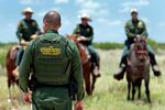 U.S. Border Patrol agents work in a field near Carrizzo Springs, Texas on July 3
