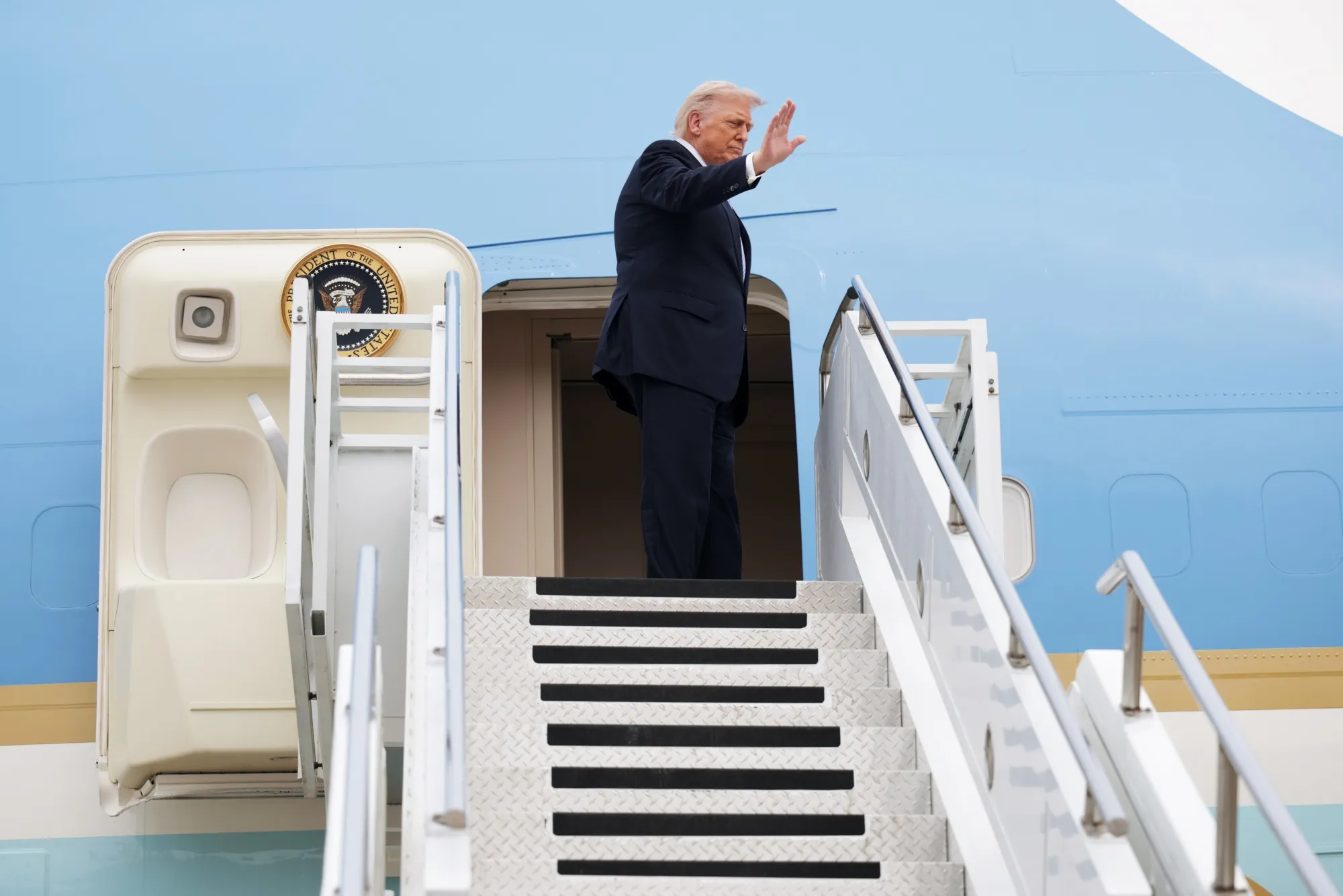 U.S. President Donald Trump waves as he prepares to board Air Force One at the conclusion of his visit to China (Photo by Alex Wong/Getty Images)