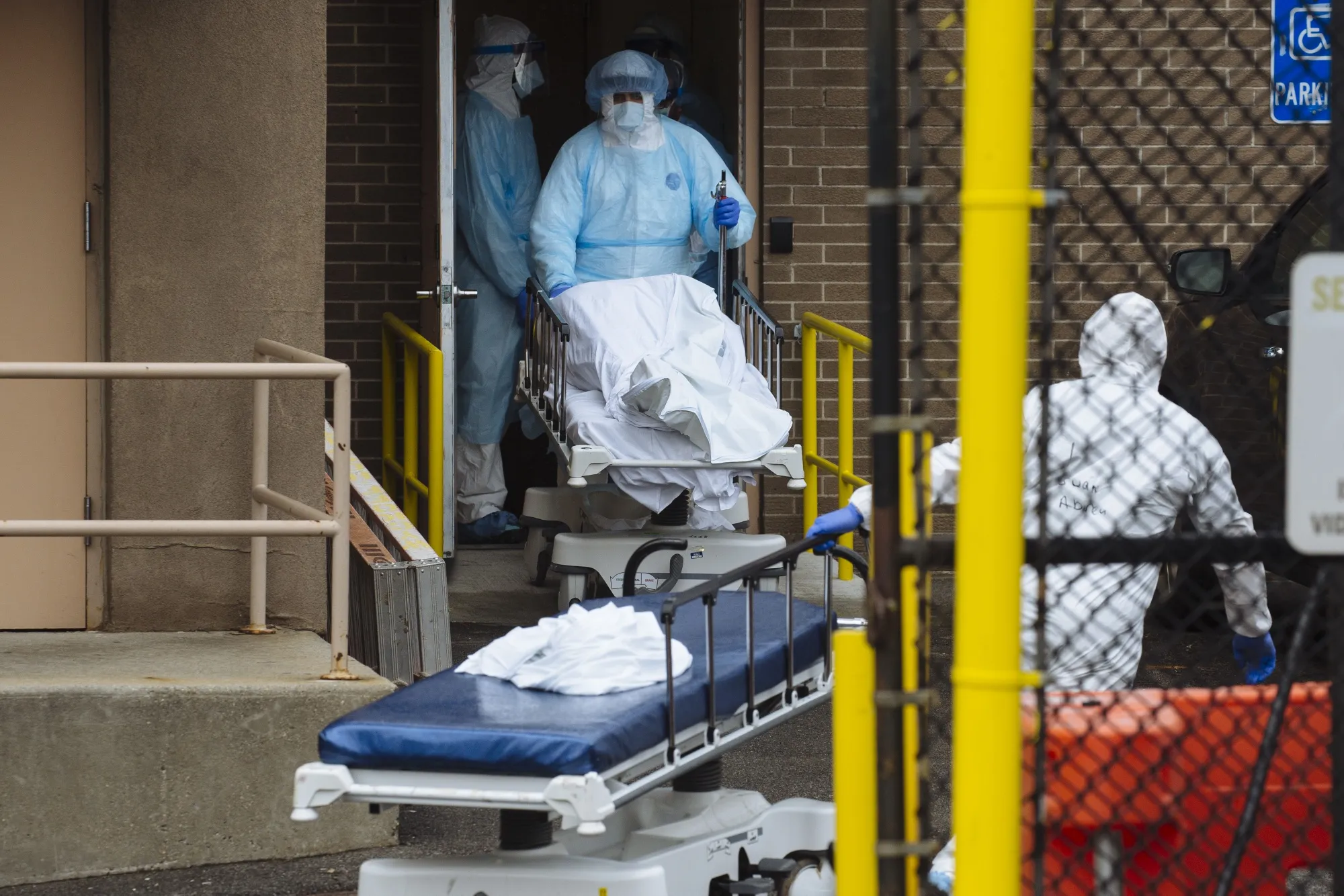 Medical workers move the body of a deceased patient to a refrigerated overflow morgue outside a medical center in Brooklyn, New York on April 3.