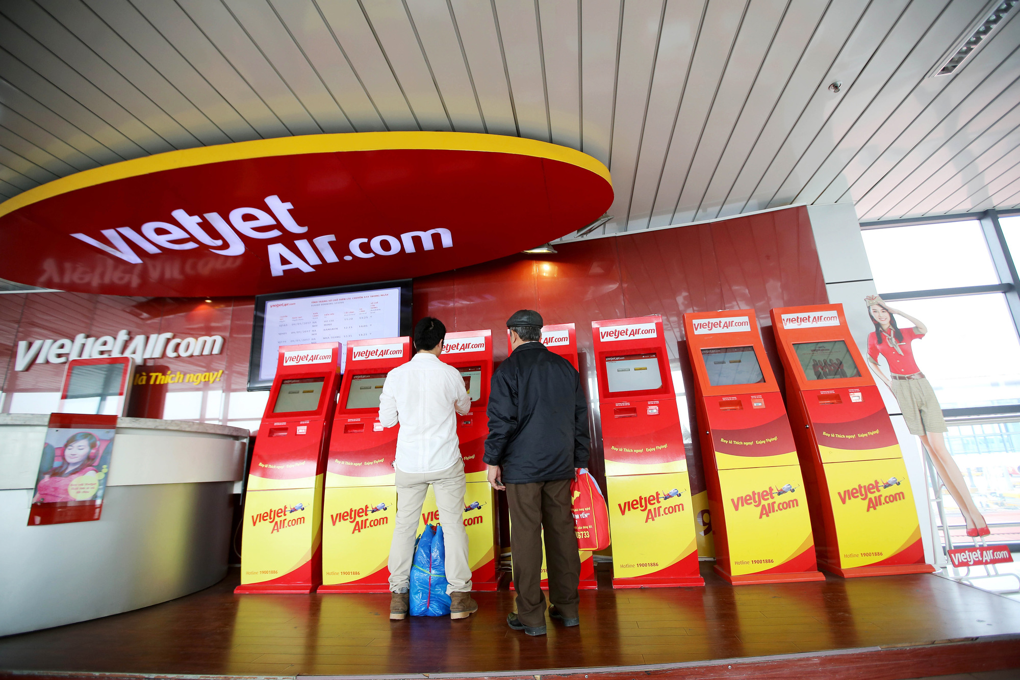 Passengers use an automated check-in machine for VietJet Air, operated by VietJet Aviation Joint Stock Co., at Noi Bai International Airport in Hanoi, Vietnam, on Monday, Jan. 9, 2017. VietJet, the Vietnam carrier known for its bikini-clad flight attendants, expects profit to surge 30 percent this year on rising passengers as it prepares for its Ho Chi Minh City Stock Exchange listing debut in February.