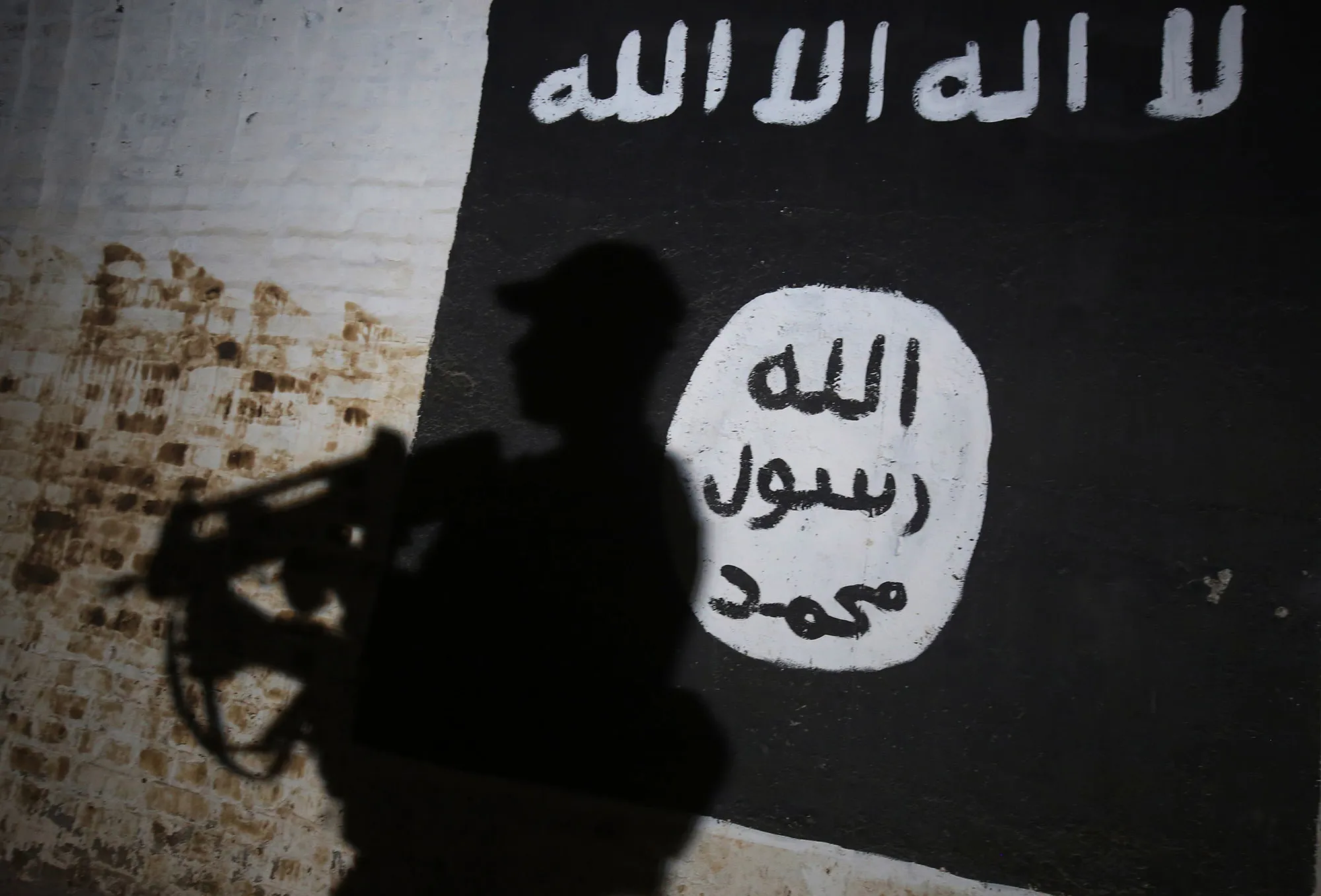 A member of the Iraqi forces walks past a mural bearing the logo of the Islamic State&nbsp;group in a tunnel&nbsp;on the southern outskirts of Mosul.