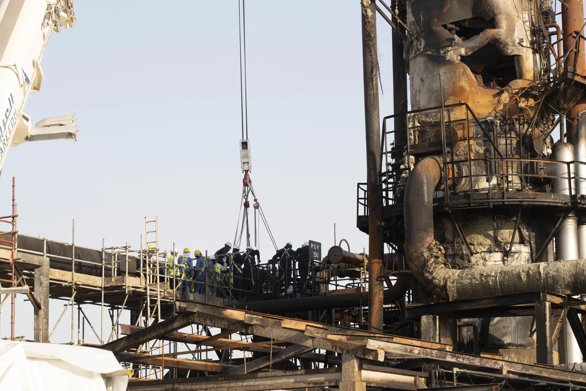 Workers repair a damaged refining tower at Saudi Aramco's Abqaiq crude oil processing plant following an attack in Sept. 2019.