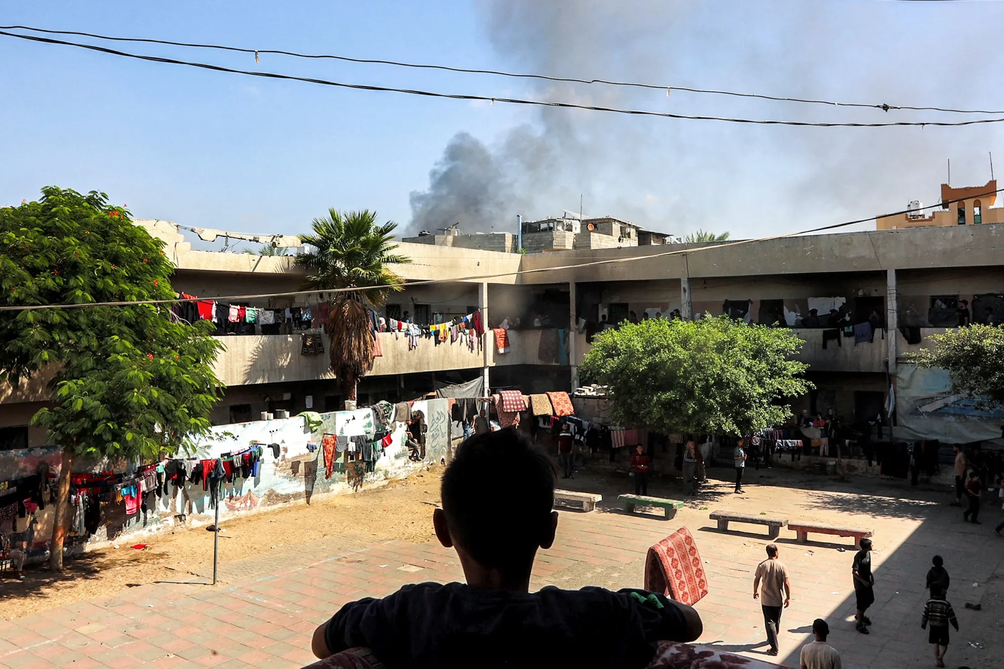 A boy watches a smoke plume rise in the Jabalia camp for Palestinian refugees in the northern Gaza Strip on Oct. 9.