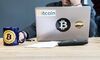 FILE: An employee uses a laptop computer branded with bitcoin logos inside the offices of La Maison du Bitcoin bank in Paris, France, on Thursday, Nov. 23, 2017. The great cryptocurrency crash of 2018 is heading for its worst week yet. Bitcoin sank toward $4,000 and most of its peers tumbled on Friday, extending the Bloomberg Galaxy Crypto Index’s weekly decline to 25 percent. That’s the worst five-day stretch since crypto-mania peaked in early January.