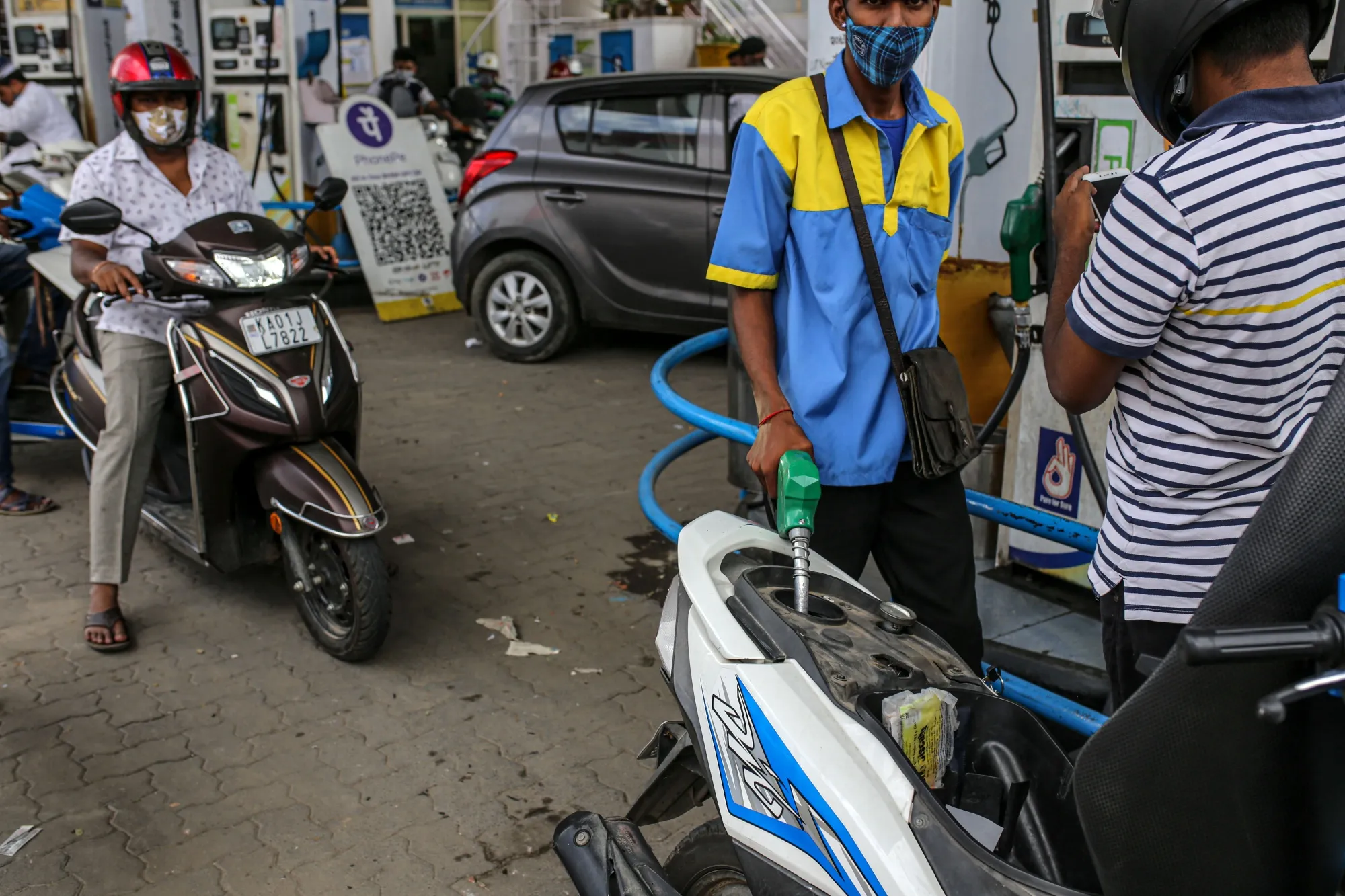 Motorcyclists refuel at a&nbsp;gas station in Bengaluru, India, on&nbsp;June 21.