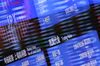 The logo of Japan Exchange Group Inc. (JPX), the operator of the Tokyo Stock Exchange (TSE), is displayed on an electric board, seen through glass panels reflecting market indices, at the bourse in Tokyo, Japan, on Thursday, Dec. 17, 2015.