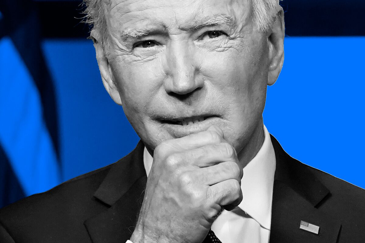 Close up of President Biden with his right fist near his chin in black and white, against a blue background with a partial view of the American flag