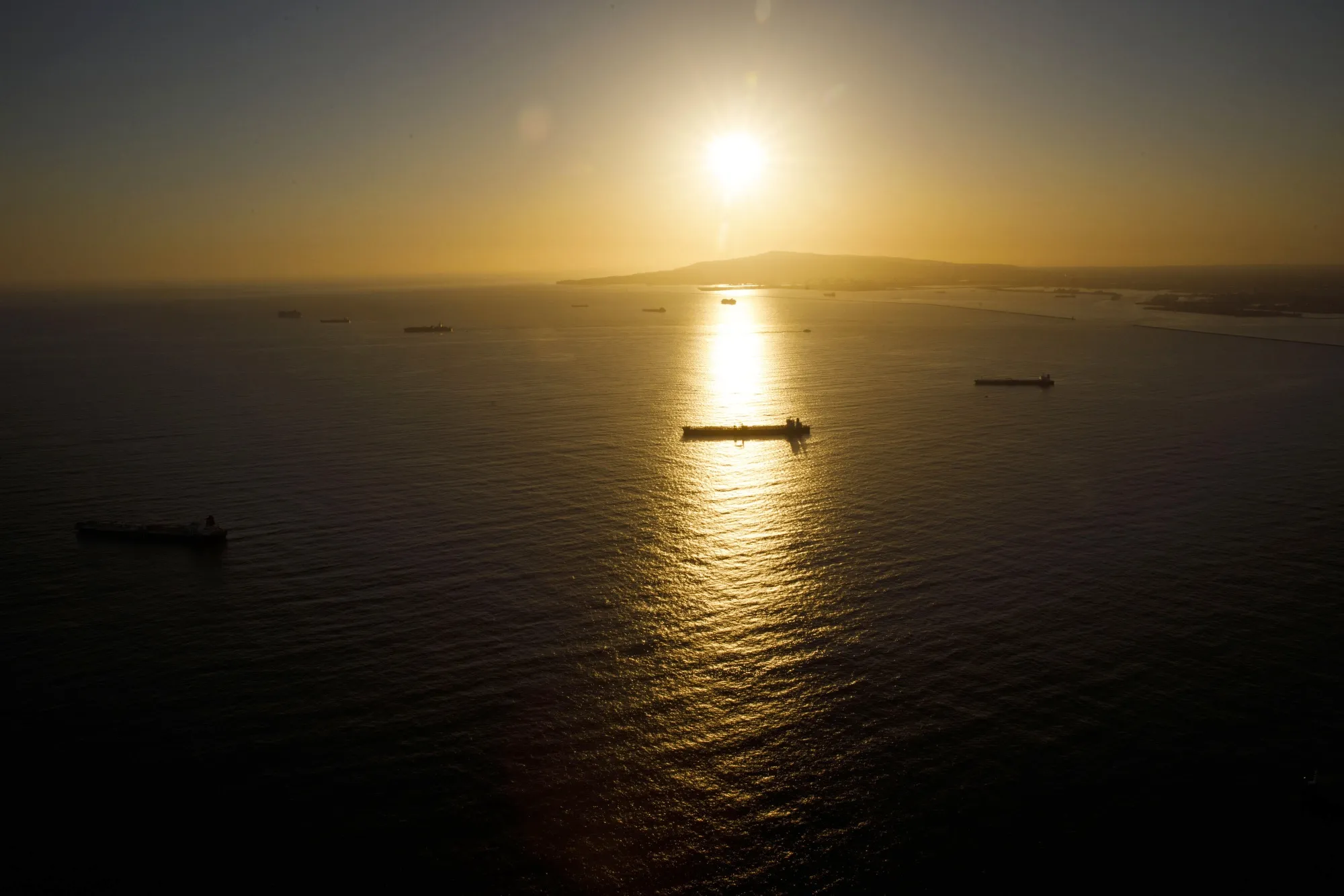 Oil shipping tankers anchored off Long Beach at sunset in California.