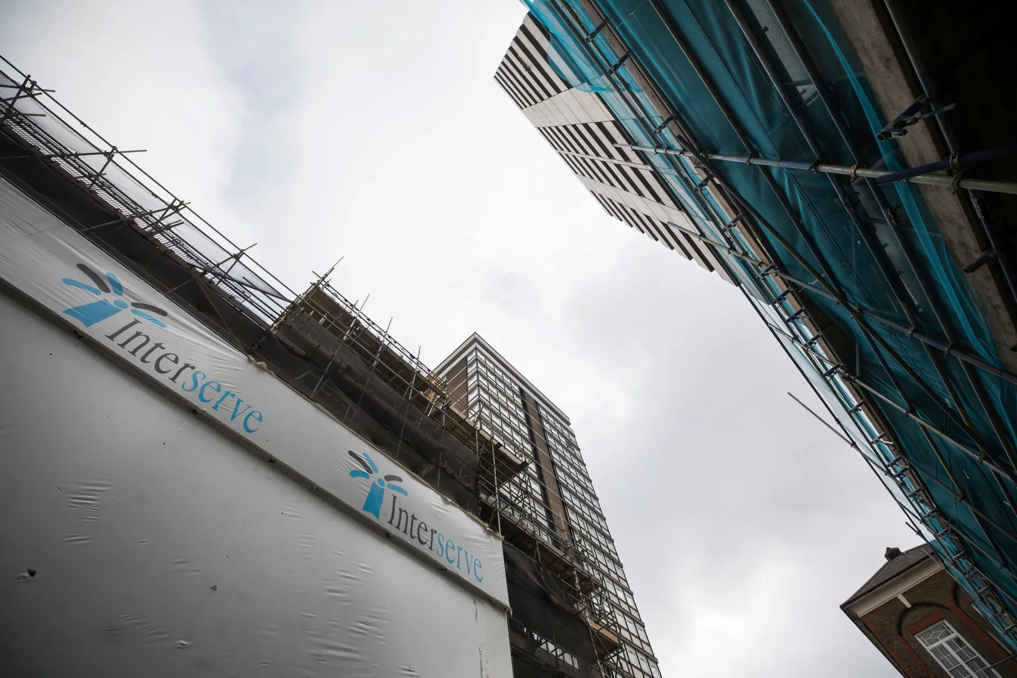 The Interserve Plc logo sits on a hoarding at the construction site in London.