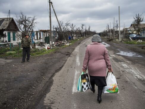 A woman carries walks back to the village of Nikishino in Ukraine, on April 21, 2015.