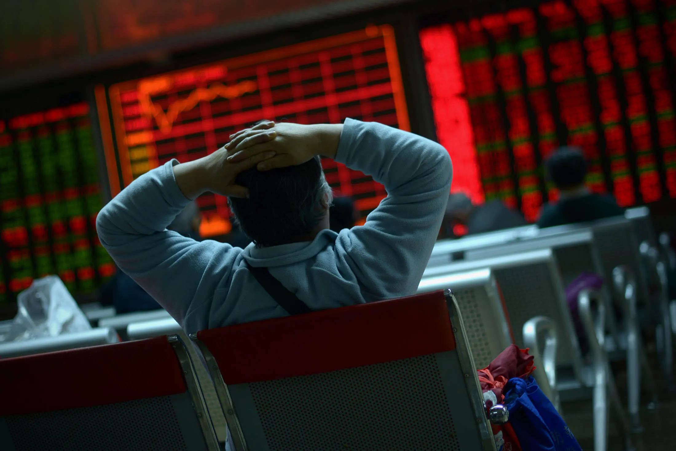 TOPSHOT - An investor looks at screens showing stock market movements at a securities company in Beijing on January 8, 2016. Chinese equities led another day of volatility across Asia on January 8 as investors were panicked by Beijing's attempts to stabilise its beleaguered markets, with fears growing the global economy could be teetering. AFP PHOTO / WANG ZHAO / AFP / WANG ZHAO (Photo credit should read WANG ZHAO/AFP/Getty Images)
