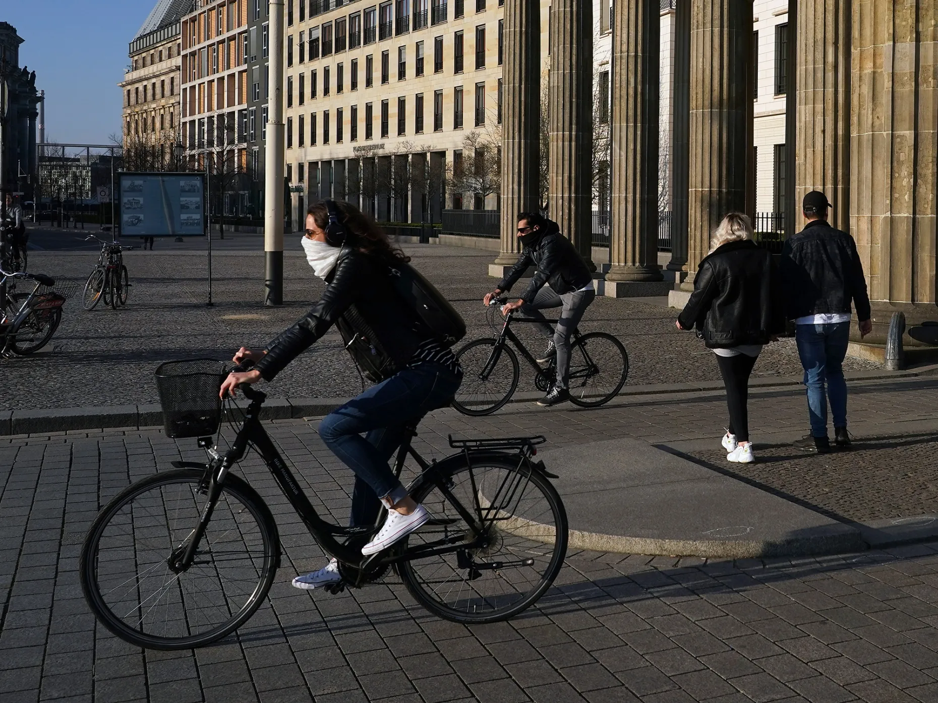 Cyclists and pedestrians pass near the Brandenburg Gate monument in Berlin, on April 6.