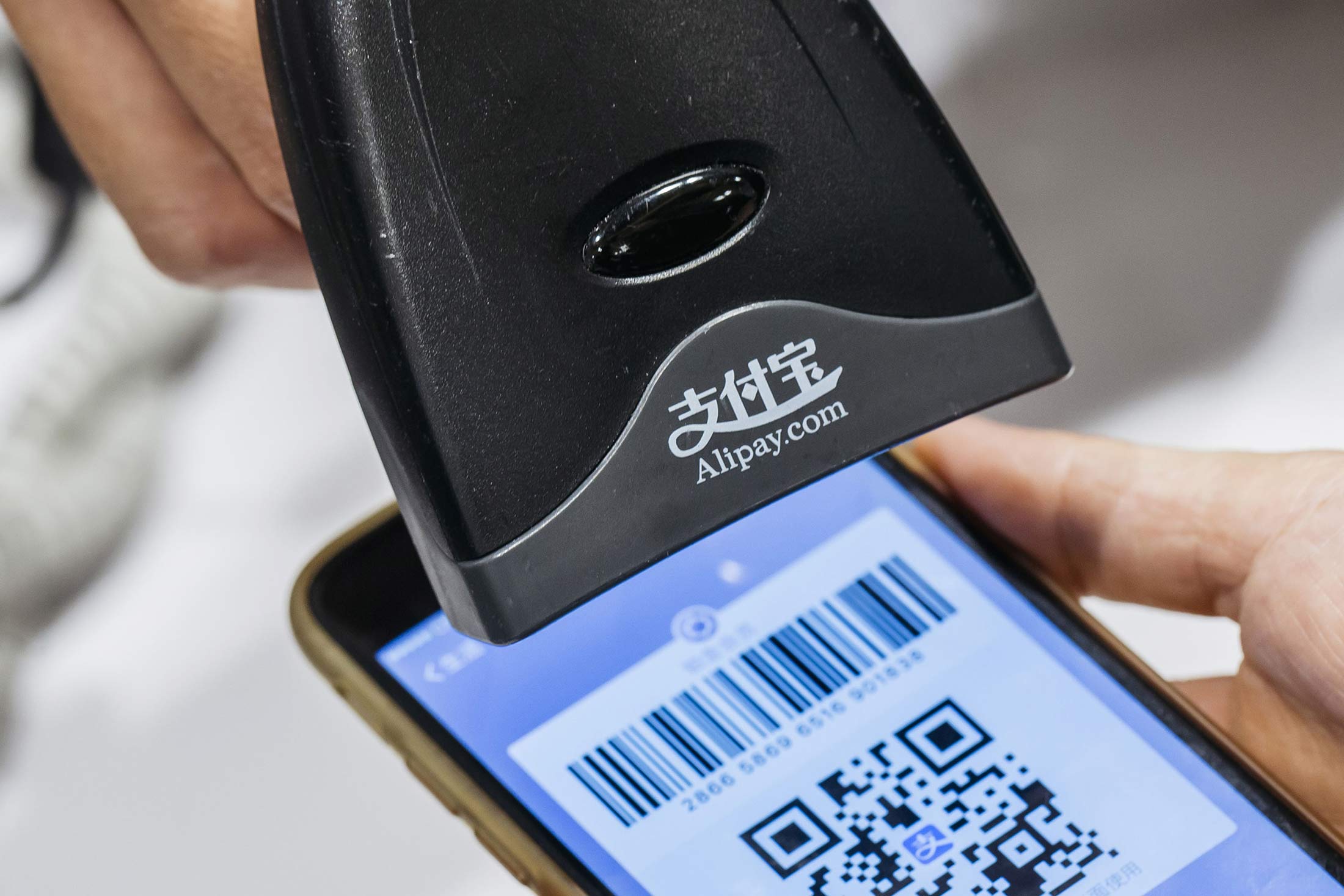An employee scans a quick response (QR) code displayed on the Ant Financial Services Group's Alipay app, an affiliate of Alibaba Group Holding Ltd., inside a Sa Sa International Holdings Ltd. store in an arranged photograph in Hong Kong, China, on Tuesday, Nov. 1, 2016. The urgency to prepare regulatory environments for fintech is growing as banks begin offering digital services such as biometric authentication and as mobile-payment systems such as Apple Pay and AliPay are introduced around the region.
