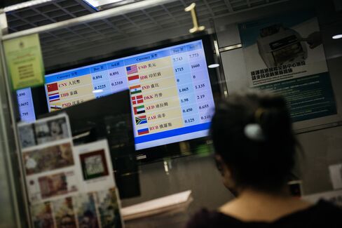 PFCE店舗のモニターで為替レートを調べる顧客